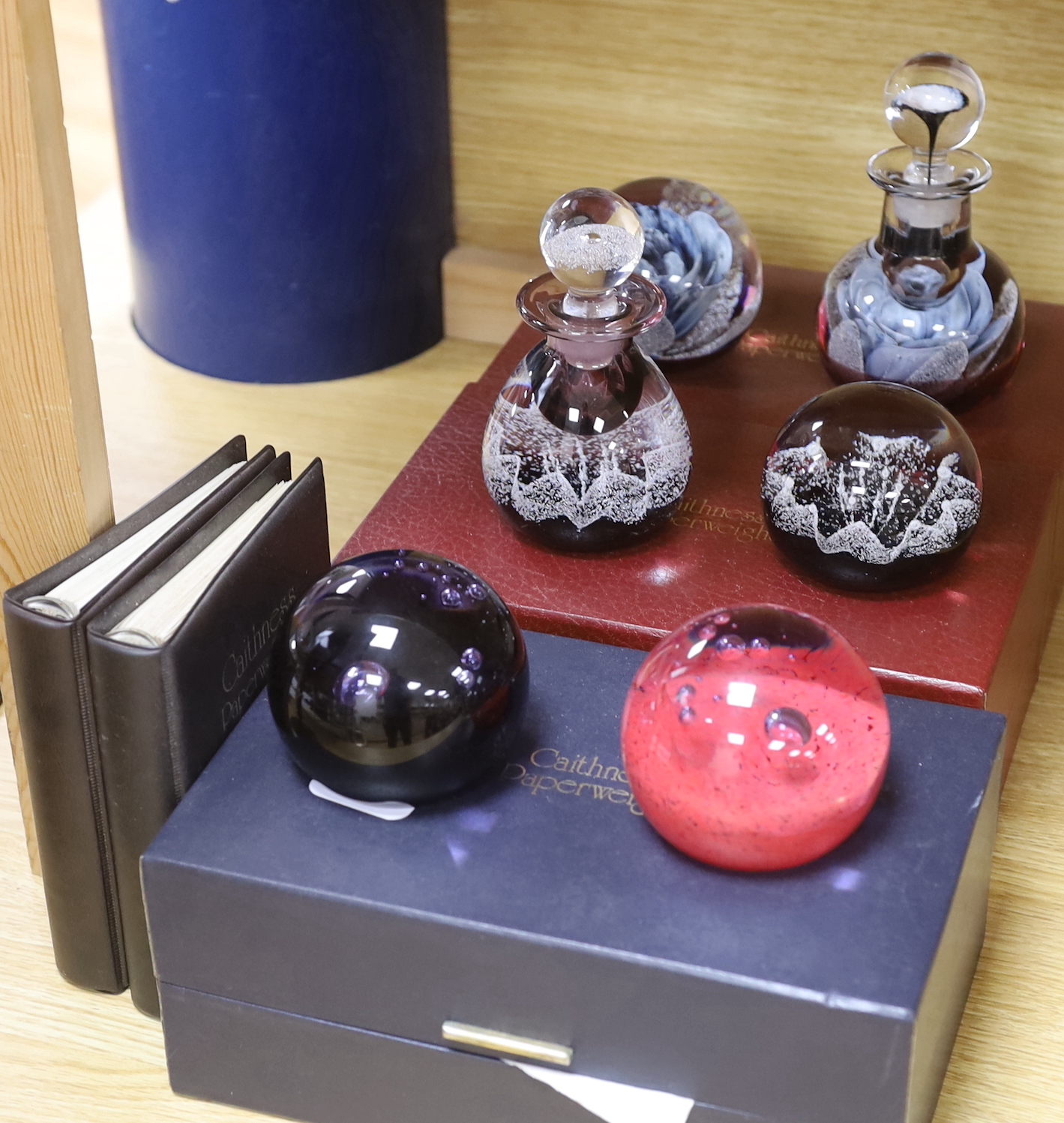 Caithness, three boxed sets comprising scent bottles and paperweights together with two Caithness Collector's Guides, each with boxes, limited editions, the largest 15cm high